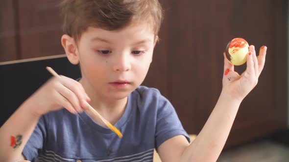 Easter Celebration Concept. Happy Little Boy Decorating Easter Eggs for Holiday.