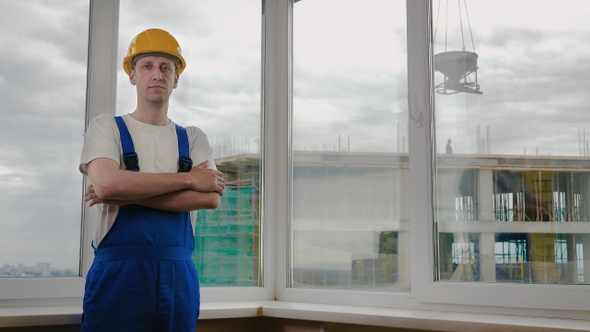 Serious confident worker with arms crossed wearing protective