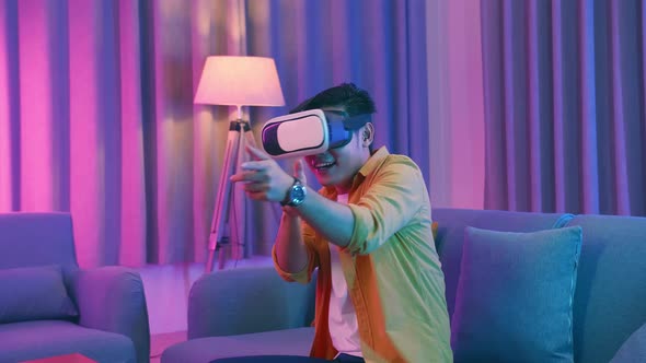 Young Asian Man Playing Game In Virtual Reality At Home