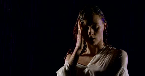 Portrait of a Dark-haired Girl in a White Shirt, Which Stands on a Black Background