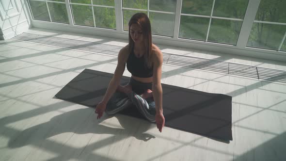 Wellness, Young Female Meditates and Does Yoga, a Calm Mood, Relaxing in a White Room Filled with