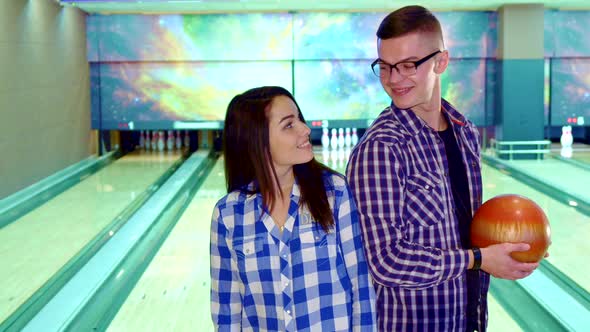 Boy and Girl Look at Each Other at the Bowling