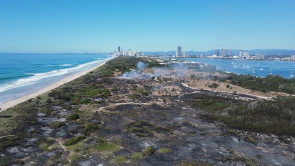 Popular holiday nature reserve destroyed by fire close to a city beach and boating harbour. Panning