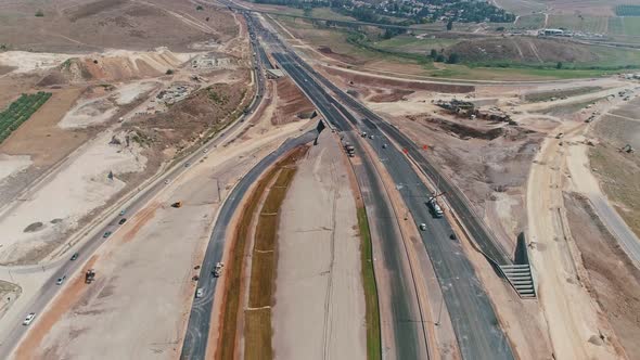 Aerial footage of large highway construction project with tunnels and bridges