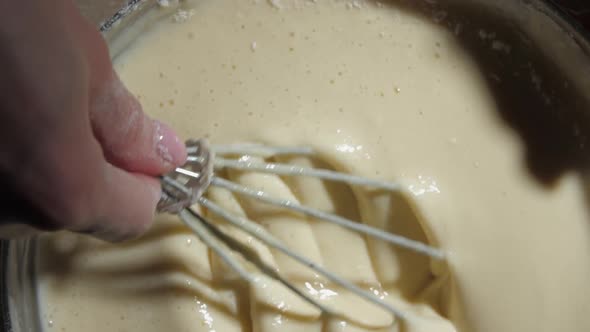 Lady Hand Holds Metal Whisk and Mixes Pancakes Dough