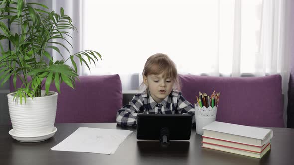 Girl Doing Online Homework Using Digital Tablet Computer. Distance Education