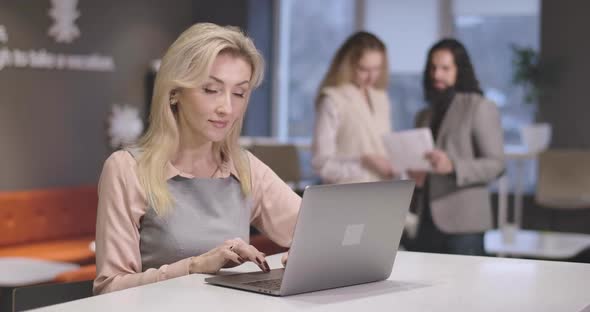 Portrait of Young Beautiful Caucasian Woman Typing on Laptop Keyboard. Portrait of Confident