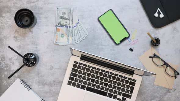 Man putting cash money on work table with green screen phone