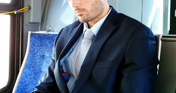 Businessman using mobile phone while travelling