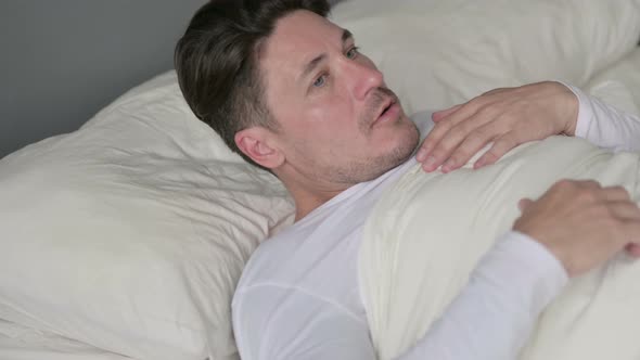 Scared Middle Aged Man Waking Up From Nightmare in Bed 