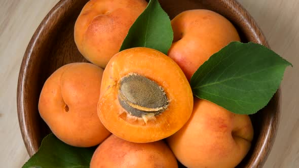 Apricots rotating in wooden bowl top view