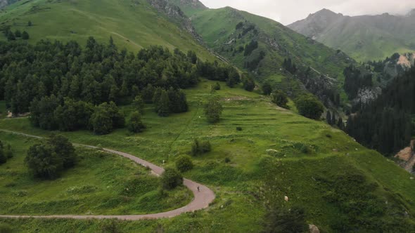 Man Ride Bicycle on the Mountain Road Aerial Shot