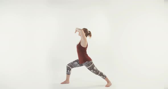 Young attractive woman performing Yoga routine on a white studio background