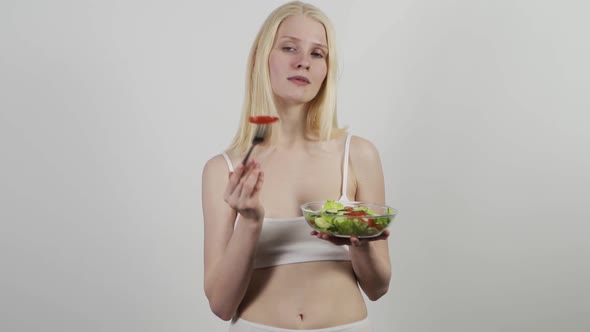 Beautiful Slender Woman Eating Tomato and Cucumber Salad Isolated on White Background