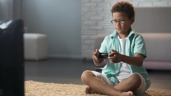 Male Child Behaving Aggressively While Losing Online Game, Playing on Console