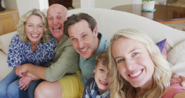 Portrait of happy caucasian family taking selfie in living room