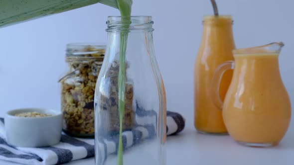 Woman Preparing Cooking Seasonal Matcha Green Vegan Smoothie Pouring in Glass Bottle with Chia Seeds