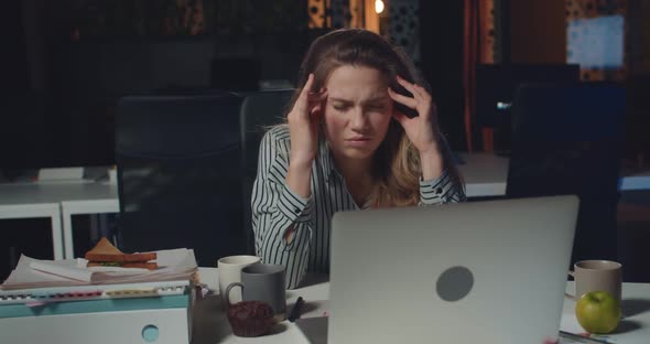 Front View of Tired Businesswoman Massaging Templates and Forehead To Concentrate While Working Long