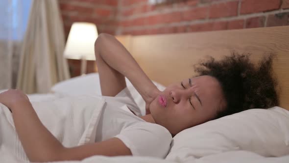 African Woman Having Neck Pain While Sleeping in Bed