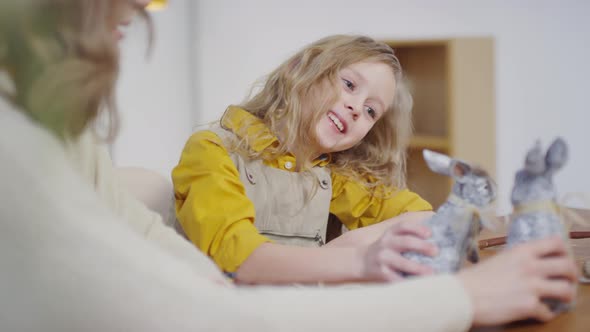 Mother and Daughter Playing with Easter Bunny Figurines