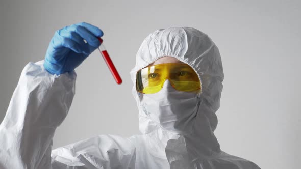 The Doctor a Woman Holds a Test Tube with a Positive Coronavirus Test in Her Hand and Looks at It