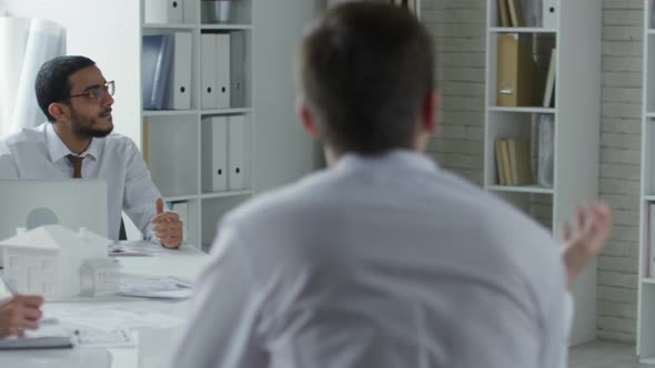 Middle Eastern Architect Speaking with Coworkers in Office