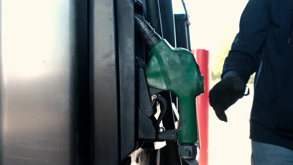 Close Up of Man Hand Putting Out a Green Fuel Nozzle