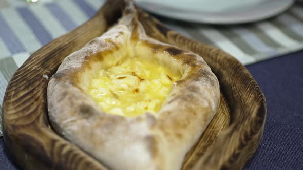 Khachapuri in Adjarian on a Wooden Plate