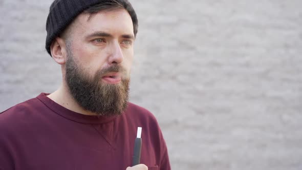 Slow motion, a man blows smoke from his mouth