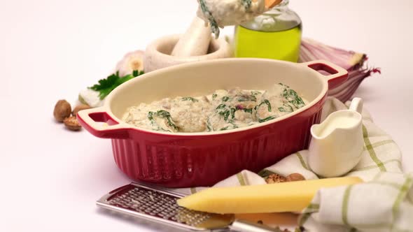 Delicious Small Meatballs with Spinach in a Creamy Sauce in Baking Dish