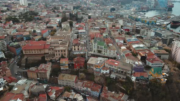 Aerial orbit of colorful houses and Lutheran Church in Cerro Concepcion, Valparaiso city and Sea Por