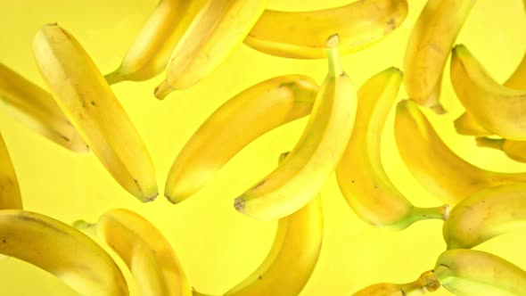 Super Slow Motion Shot of Fresh Bananas on Yellow Background Flying Towards Camera at 1000Fps