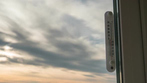 Temperature Thermometer Outside the Window and Changing Weather in Timelapse