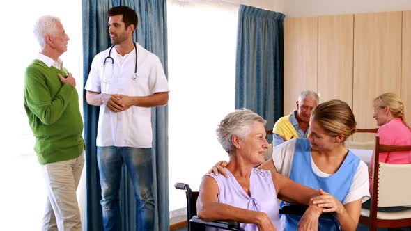 Doctor and nurse interacting with senior citizens