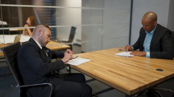 African Businessman and His Caucasian Colleague Signing Employment Contract in Office During the