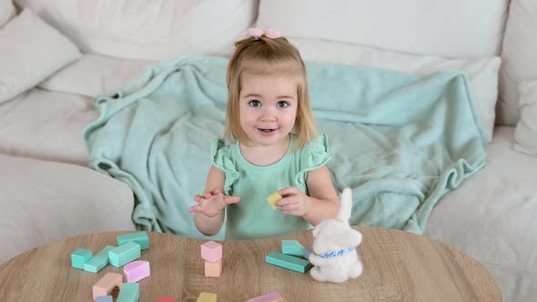 Adorable Little Girl Playing with Colorful Wooden Cubes