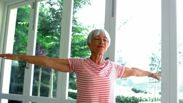 Senior woman performing stretching exercise on fitness ball