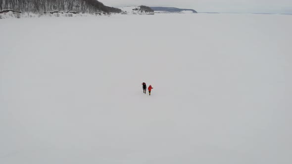 Pair of Trekkers Walking in Winter Day, Stepping Over Snow Fields, Top View From Drone, Aerial Shot