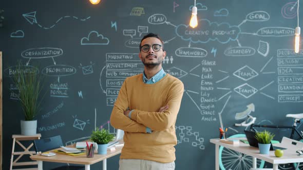 Portrait of Handsome Arab Guy Creative Worker Standing in Office with Chalkboard