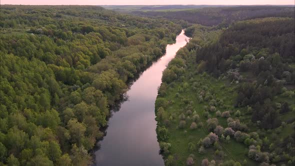 View of the river from above. Flight over water and forest trees from a height