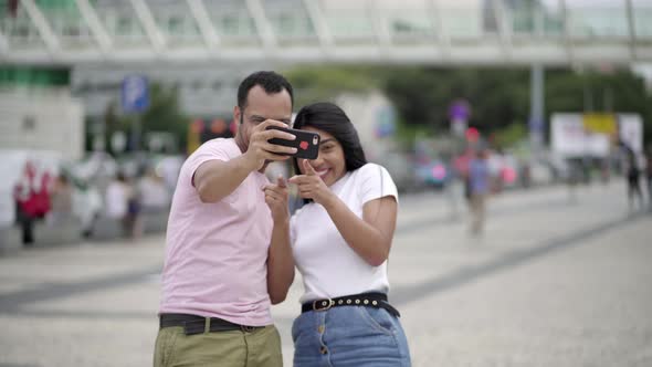 Happy Young Couple Posing for Self Portrait on Square