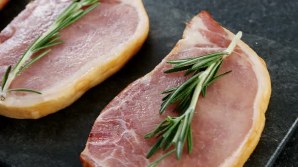 Raw sirloins arranged on the board with rosemary