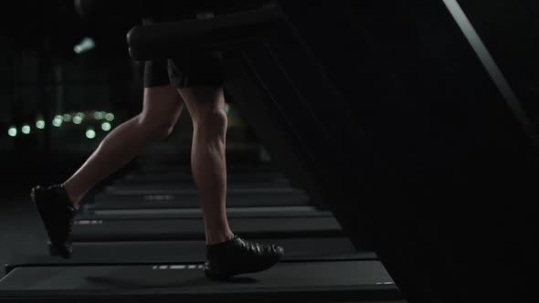 Ypung Athletic Man Run on a Treadmill Aerobic Exercise and Endurance Training in the Gym Night