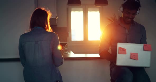 Portrait of Two Friends Using Mobile Phone and Listening to Music