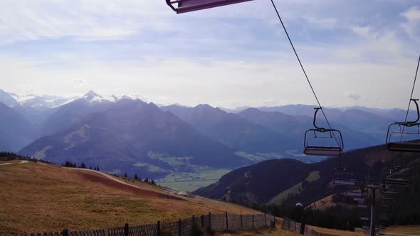 Ski Lifts At The Schmittenhohe Mountain With A View Of Kitzbuhel Alps In Austria. aerial, forward