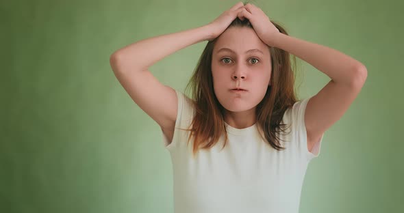 Mad Angry Woman in Tshirt Holds Head Posing for Camera