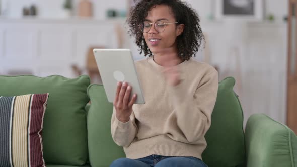 Video Chat on Tablet By African Woman on Sofa