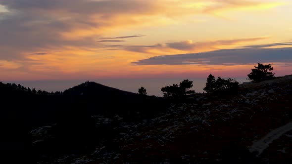 Black Silhouette Of Hill At Sunset With Clouds