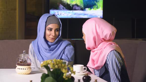 Two Beautiful Muslim Girl in Cafe. Young Girls in Hijabs Spend Time Together