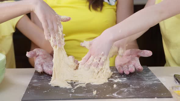 Children's Hands Close Up Knead Pizza Dough. Children Help Their Mother To Cook